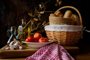 Still life with extra virgin olive oil, tomatoes, garlic and bread.