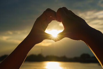 Heart hand finger in sunset landscape nature, Woman making heart shape with Hands