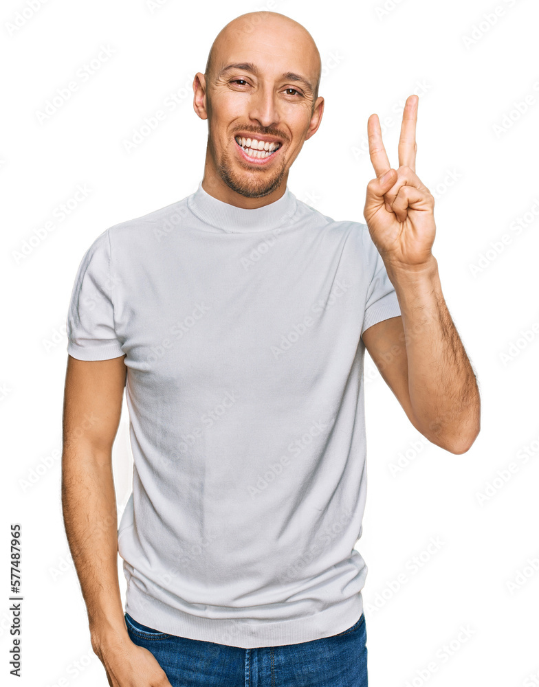 Wall mural bald man with beard wearing casual white t shirt showing and pointing up with fingers number two whi