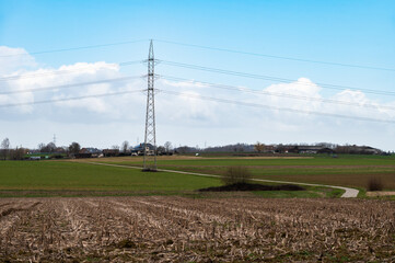 Cropped agriculture soil, green farmland and a high voltage electricity pool, Relegem, Belgium