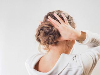  A beautiful girl gathered her wavy hair in a low bundle. Modern festive hairstyle for long brown...