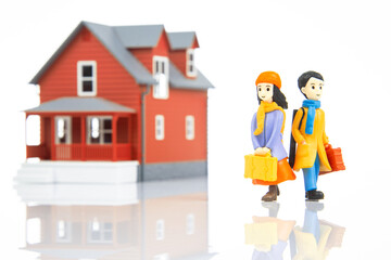 miniature people. romantic couple of young people near the house model on a white background. friendship and great relationship