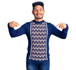 Handsome latin american young man wearing casual winter sweater looking confident with smile on face, pointing oneself with fingers proud and happy.