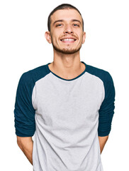 Hispanic young man wearing casual clothes looking positive and happy standing and smiling with a confident smile showing teeth