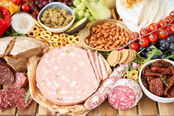 Parma sausage close-up. Table full of mediterranean appetizers, tapas or antipasto. Assorted Italian food set. Delicious snack on party or picnic time. Meat and cheese. Italian style banquet. 