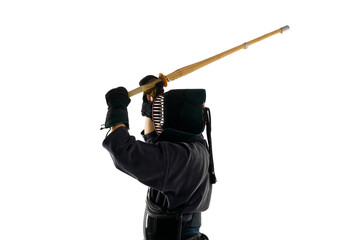 Top view. Man, professional kendo athlete in uniform with helmet training with bamboo shinai sword against white studio background. Concept of martial arts, sport, Japanese culture, action and motion
