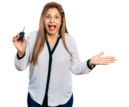 Middle age latin woman holding key of new car celebrating achievement with happy smile and winner expression with raised hand