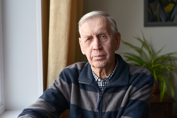 Portrait of a serious nice old man, 80 years old, looking at the camera.
