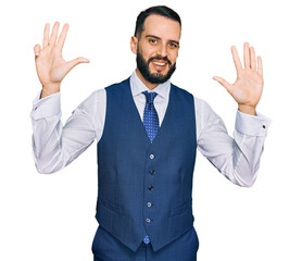 Young man with beard wearing business vest showing and pointing up with fingers number nine while smiling confident and happy.