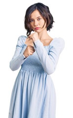 Young beautiful girl wearing casual clothes ready to fight with fist defense gesture, angry and upset face, afraid of problem