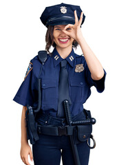 Young beautiful girl wearing police uniform doing ok gesture with hand smiling, eye looking through fingers with happy face.