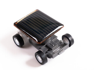 Fototapeta premium Solar powered toy car using small cells isolated on white background. Educational concept for solar powered cars, close up