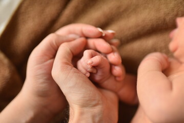 Baby feet in father hands. Tiny Newborn Baby's feet on male shaped hands closeup. Dad and his Child. Happy Family concept.