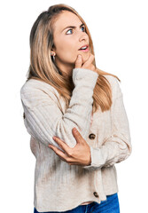 Young blonde woman wearing casual clothes thinking worried about a question, concerned and nervous with hand on chin