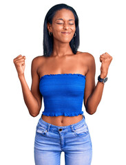 Young african american woman wearing casual summer clothes very happy and excited doing winner gesture with arms raised, smiling and screaming for success. celebration concept.