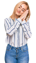 Beautiful caucasian woman wearing casual clothes sleeping tired dreaming and posing with hands together while smiling with closed eyes.