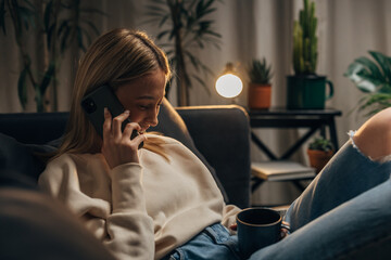 Young blonde woman is having a pleasant phone call