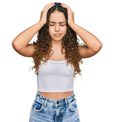 Teenager hispanic girl wearing casual clothes suffering from headache desperate and stressed because pain and migraine. hands on head.