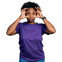 African american woman with afro hair wearing casual purple t shirt trying to open eyes with fingers, sleepy and tired for morning fatigue