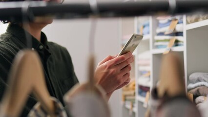 She browses clothes racks, weighing her style and budget carefully before buying clothes. A huge selection of clothes made me check the balance on my account online using a smartphone
- Powered by Adobe