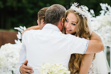 Father congratulates the brides with a marriage and hugs. man welcomes. Happy bride and groom. On...