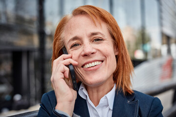 Ambitious middle-aged businesswoman, embracing unexpected challenges with a determined and professional attitude talking on mobile phone