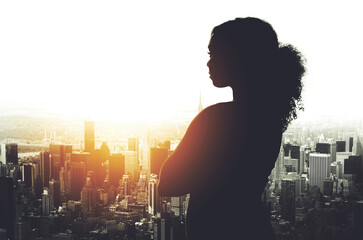 Her success has been shaped in this city. Silhouetted shot of a young businesswoman looking at a...