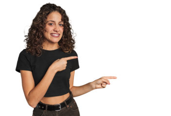 Radiant young woman with stunning curls shocked pointing with index fingers to a copy space.