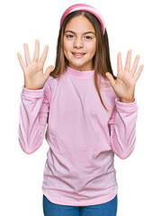 Obraz na płótnie Canvas Beautiful brunette little girl wearing casual turtleneck sweater showing and pointing up with fingers number ten while smiling confident and happy.