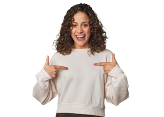 Radiant young woman with stunning curls surprised pointing with finger, smiling broadly.