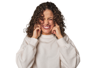 Radiant young woman with stunning curls covering ears with hands.