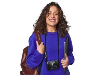 Joyful digital nomad with vintage camera and laptop.