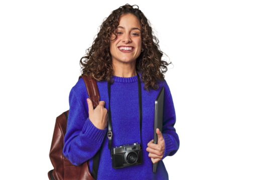 Joyful digital nomad with vintage camera and laptop.