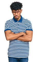 Young arab man wearing casual clothes and glasses skeptic and nervous, disapproving expression on face with crossed arms. negative person.