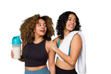 Two best friends are ready to go to the gym, one of them holds a protein shake, looks aside smiling, cheerful and pleasant.