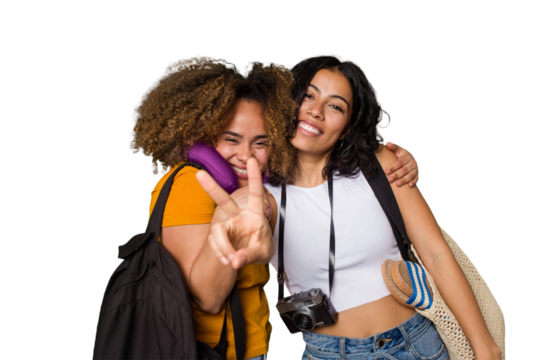 Two diverse friends on a beach vacation with vintage camera, beach bag, and travel pillow showing number two with fingers.