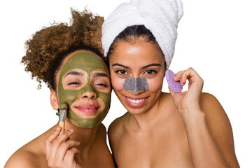 Two friends pamper themselves with facial treatments for a relaxing spa day at home, with laughter...