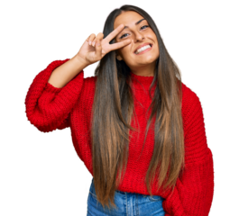 Beautiful hispanic woman wearing casual clothes doing peace symbol with fingers over face, smiling cheerful showing victory