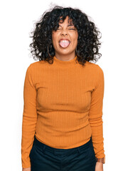 Young hispanic woman wearing casual clothes sticking tongue out happy with funny expression. emotion concept.