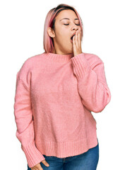 Hispanic woman with pink hair wearing casual winter sweater bored yawning tired covering mouth with hand. restless and sleepiness.