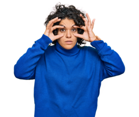 Young hispanic woman with curly hair wearing turtleneck sweater trying to open eyes with fingers, sleepy and tired for morning fatigue