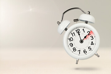 Change time. Winter time concept, on a wooden background. A white alarm clock with a minute hand...
