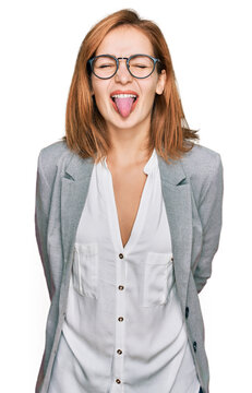 Young caucasian woman wearing business style and glasses sticking tongue out happy with funny expression. emotion concept.