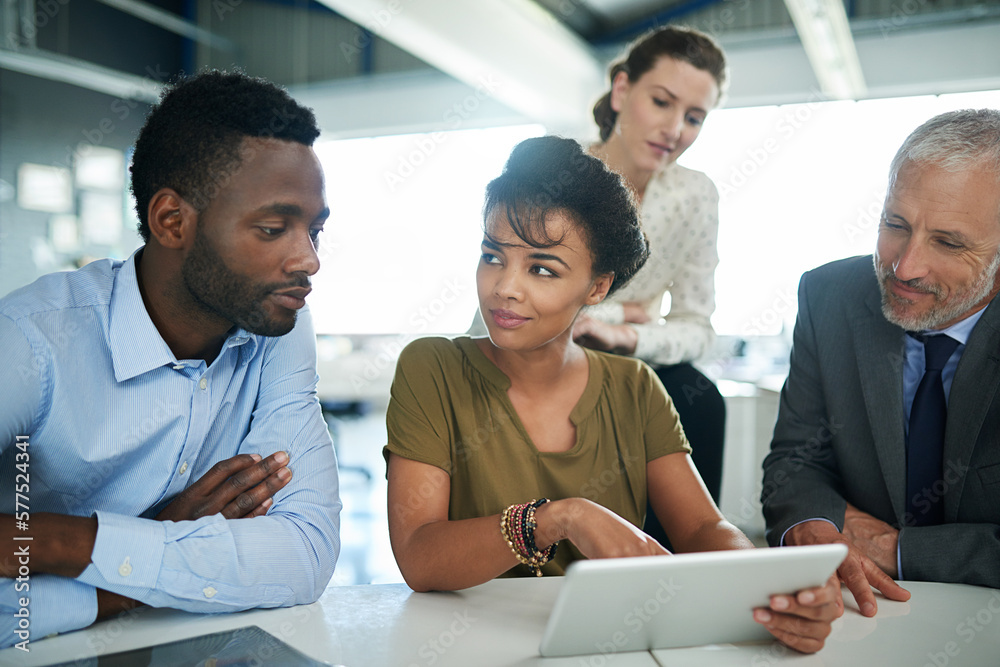 Poster everyones in on this project. shot of a group of businesspeople talking together over a digital tabl