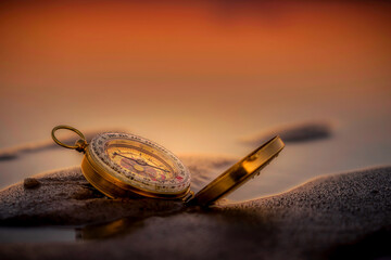Kompass am Sandstrand im Abendrot
