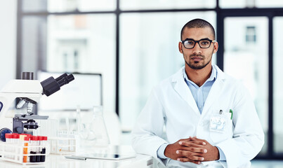 Hes an important part of the scientific lab. Cropped shot of a young male scientist working in his lab.