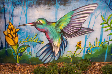 Colorful hummingbird painting on a wall in a park in Laval France