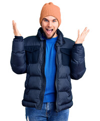 Young handsome man wearing winter clothes celebrating victory with happy smile and winner expression with raised hands