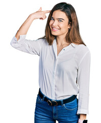 Young caucasian girl wearing casual white shirt smiling pointing to head with one finger, great idea or thought, good memory