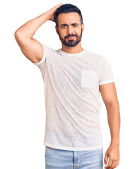 Obraz premium Young hispanic man wearing casual clothes confuse and wonder about question. uncertain with doubt, thinking with hand on head. pensive concept.